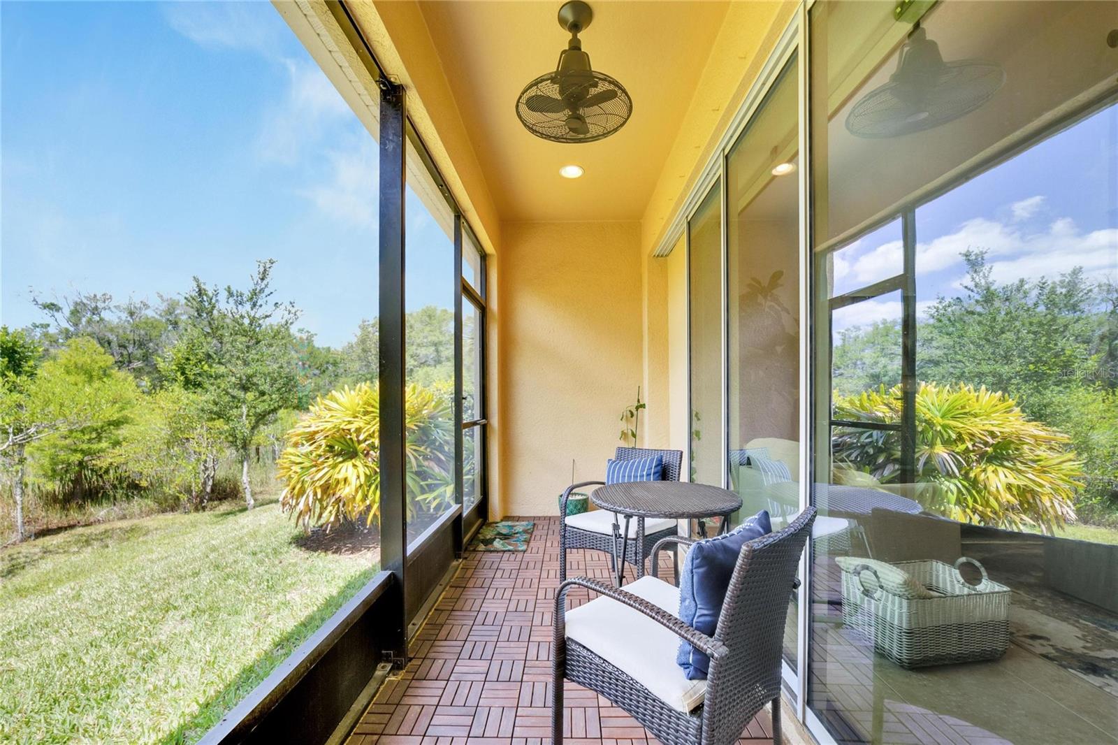 Back lanai with teak wood tiles with view of conservation at 12306 Terracina Chase Ct, Tampa, FL 33625