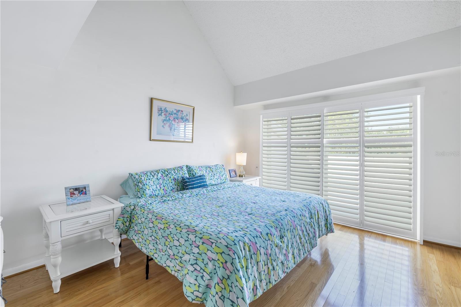 Upstairs is the Primary bedroom with high ceilings, plantation shutters, sliding doors lead to a balcony