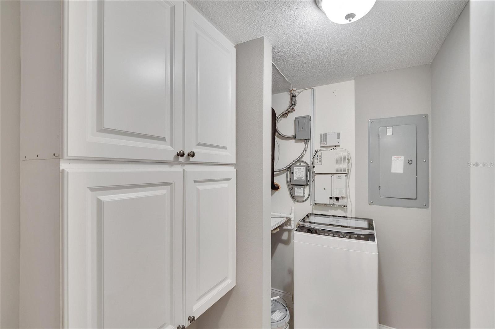 Utility room in hallway with portable washer included.