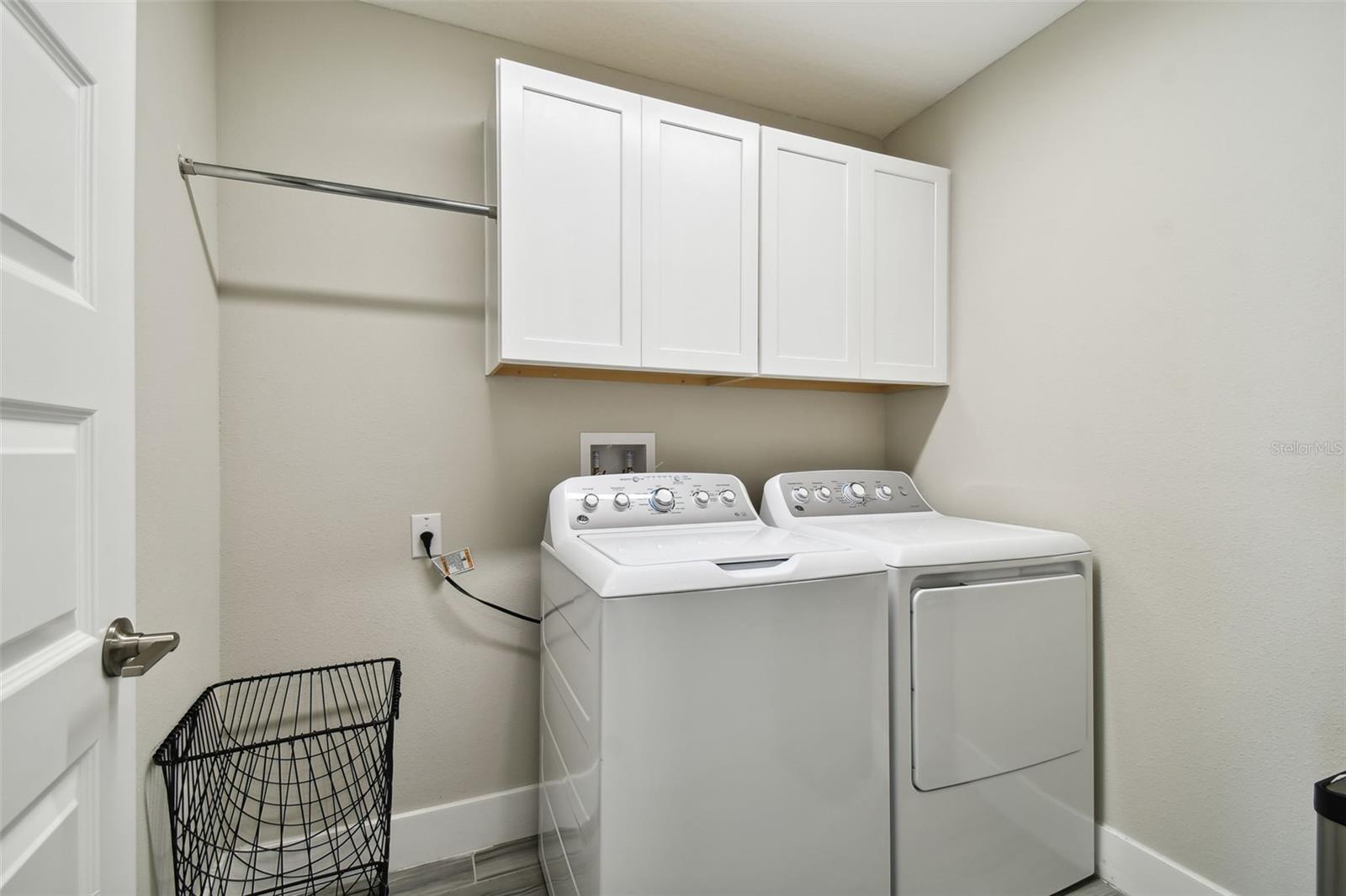 Laundry room with built-in cabinets and drying rack