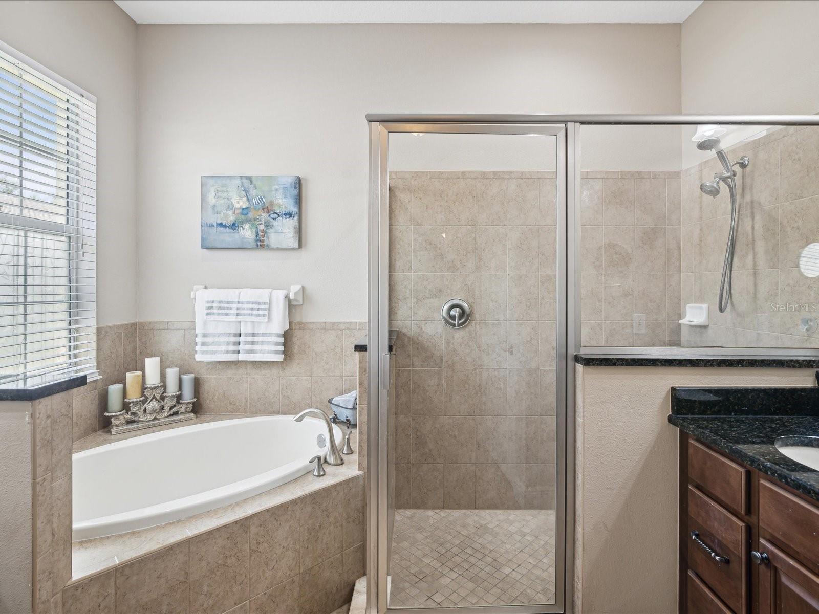 The ensuite bathroom features a luxurious soaking tub, and a walk -in framed glass shower.