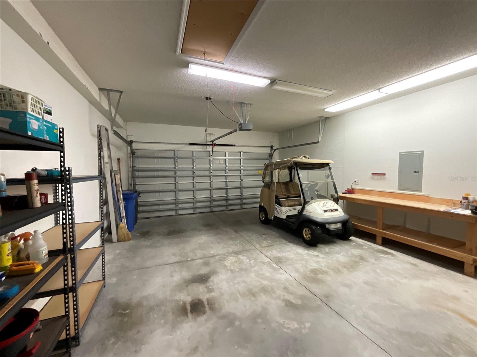 Ready for GOLF!  Garage with attic access, work bench, and storage shelves