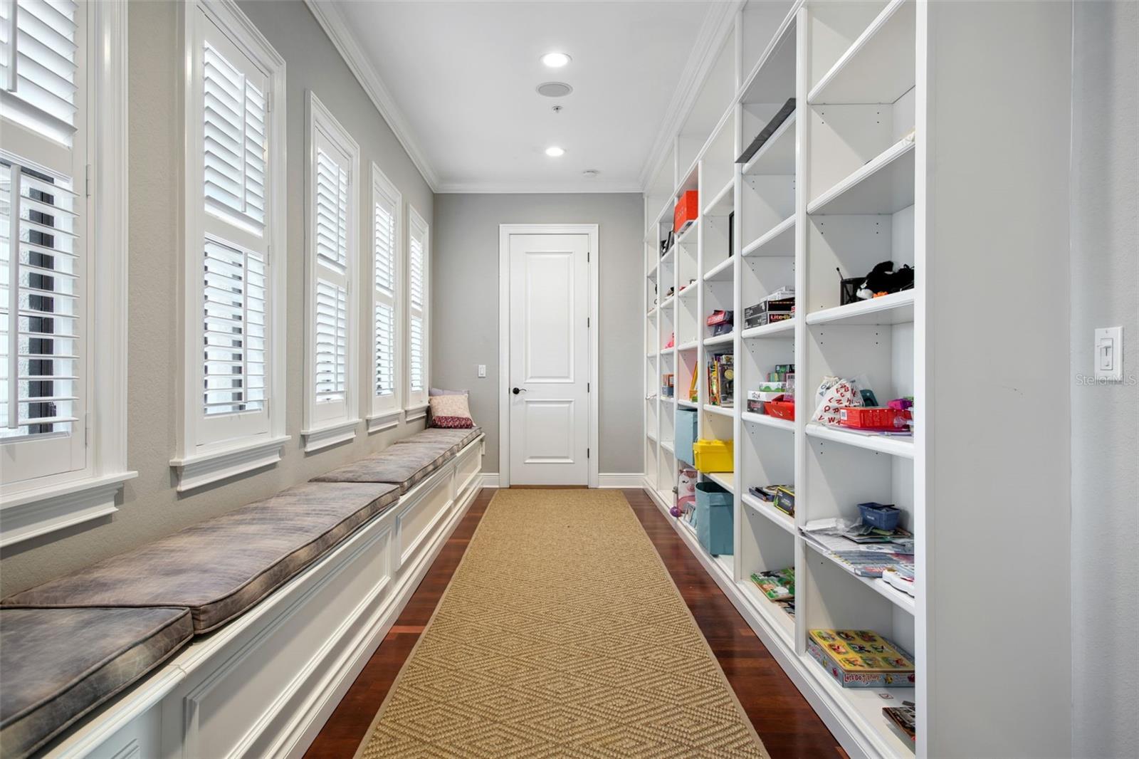 Hall between north and south bedrooms with built-in shelves and  window seat storage.  Perfect for books, toys or collectibles.