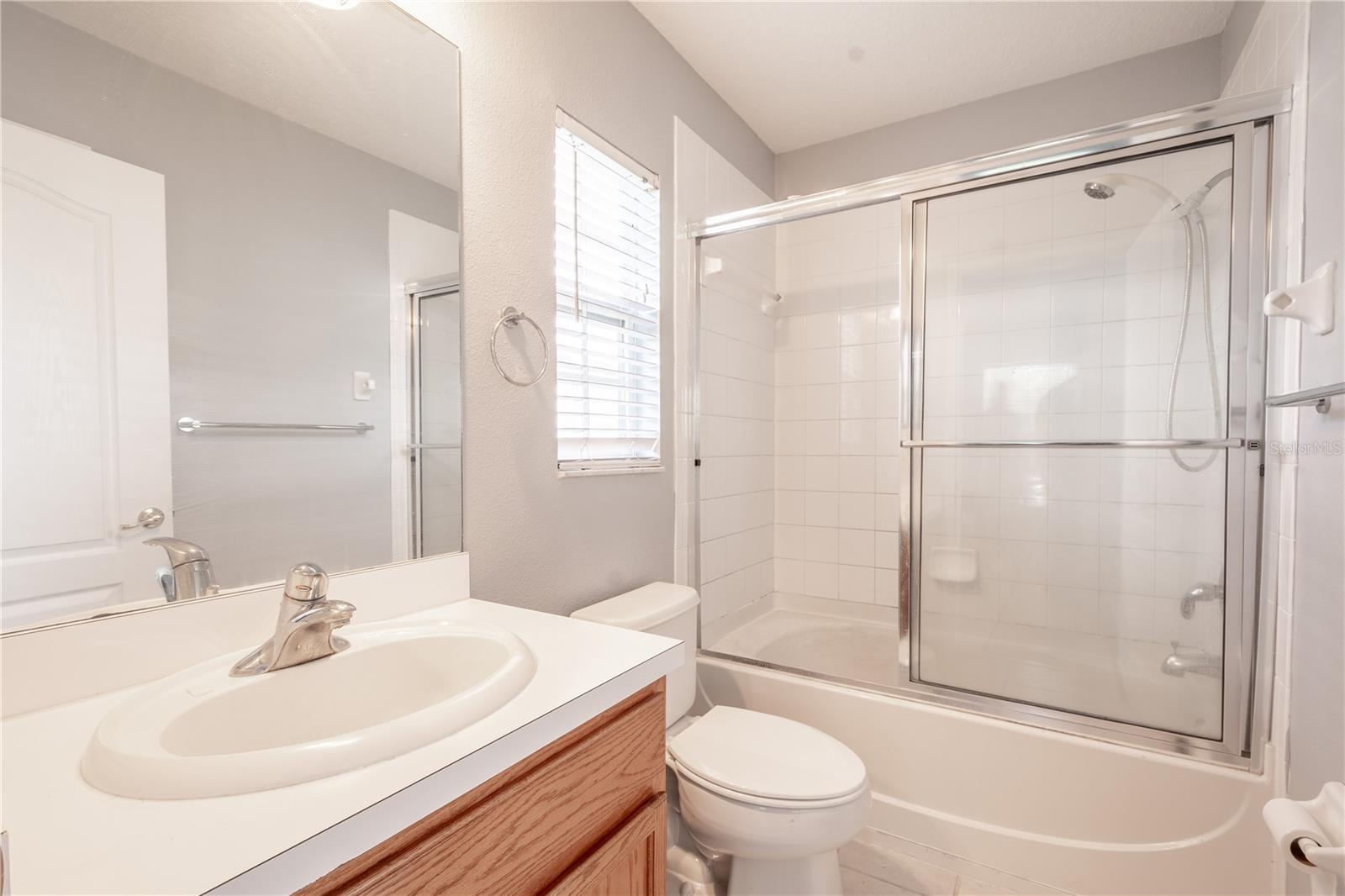 The primary ensuite features a tub with shower, and a mirrored vanity with storage.