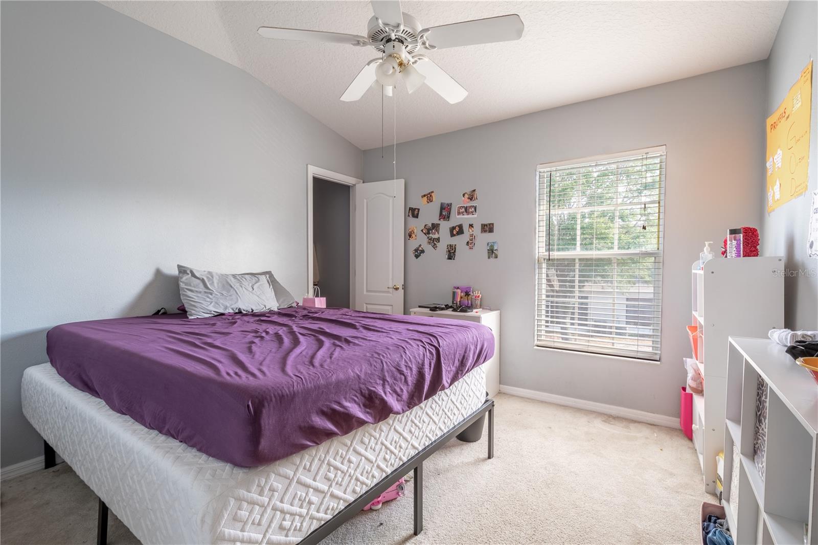 Bedroom  2 features carpet, a ceiling fan, neutral color palette and a walk in closet.