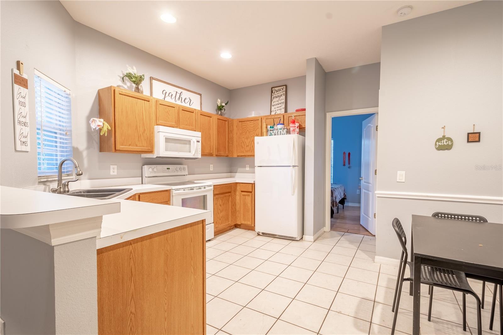 The open kitchen has wood cabinets and a full suite of appliances.