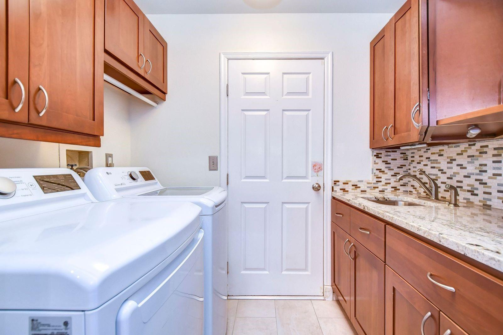 The laundry room is between the garage and kitchen and has so much storage!