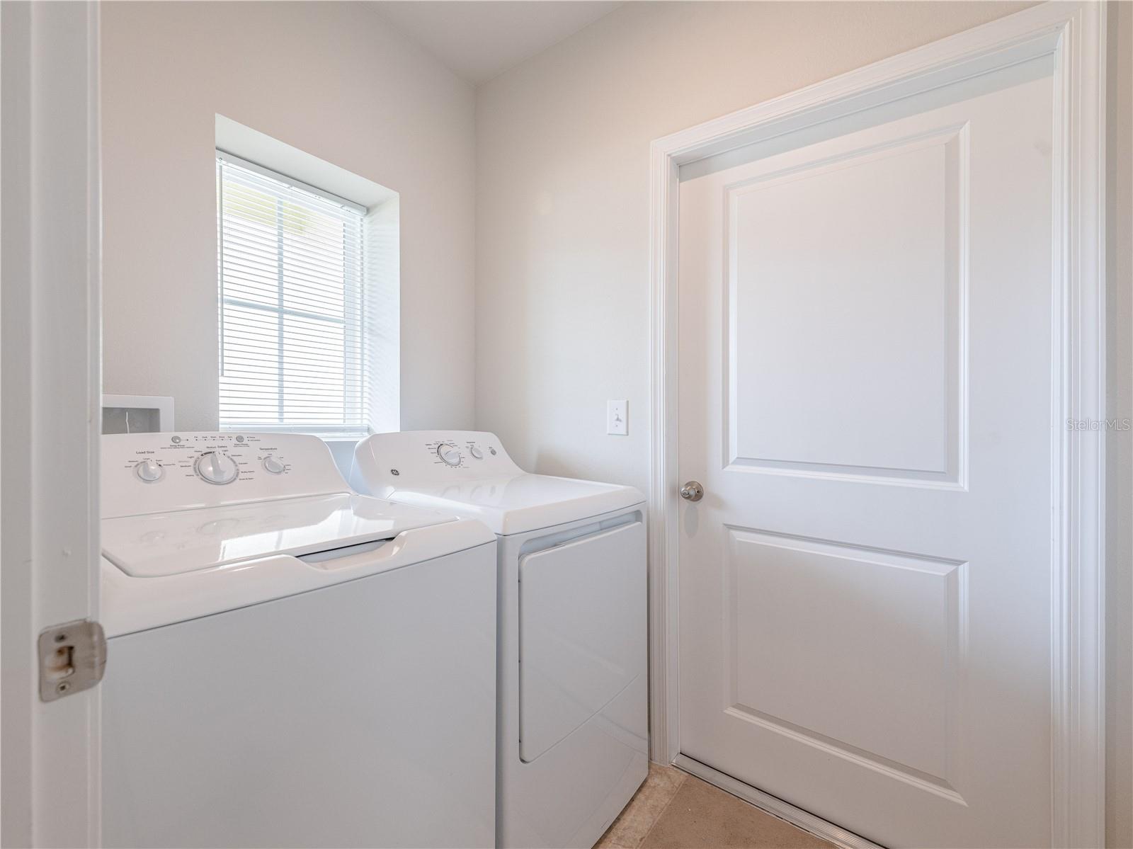 Interior laundry room with door leading to garage.
