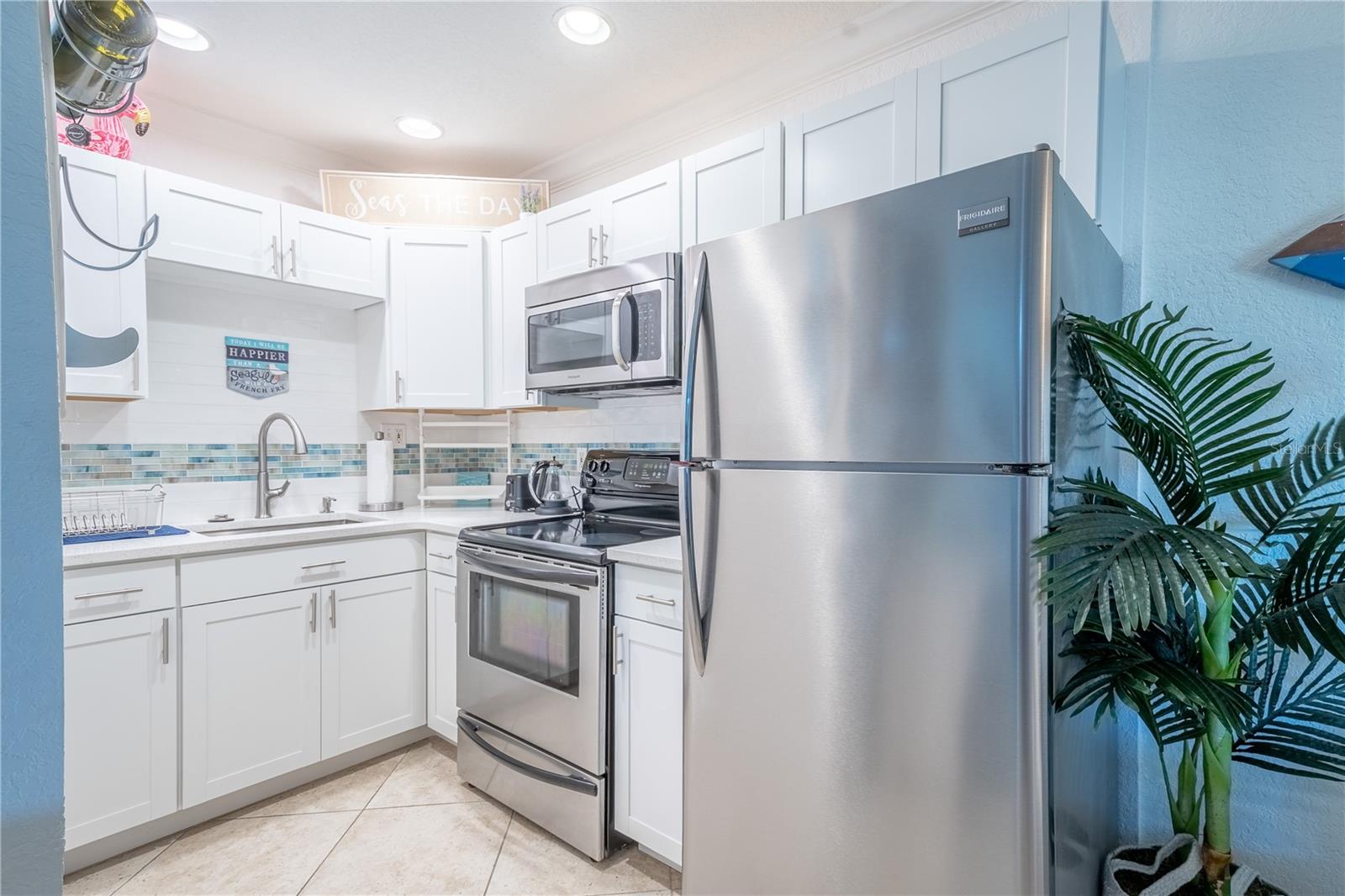 The kitchen features stainless steel appliances, sink  and cabinet pulls for a cohesive look.