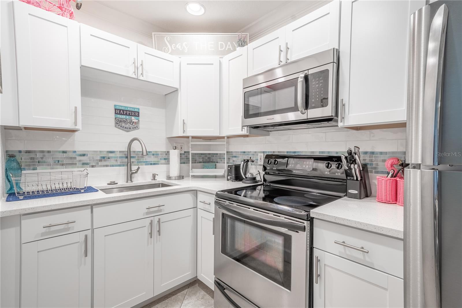 The kitchen features stones counters and plenty of cabinets for storage.