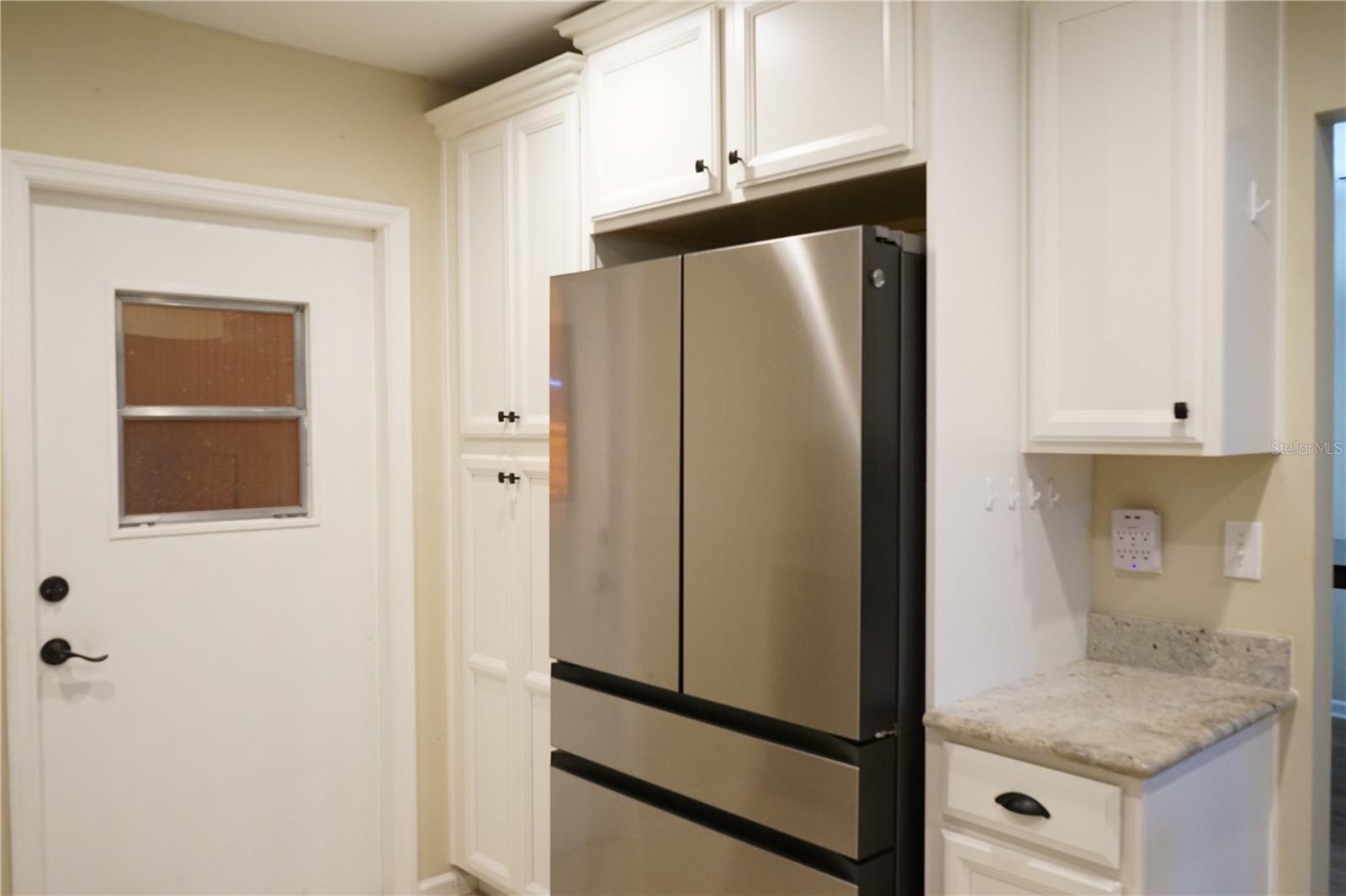 pantry next to fridge, granite tops