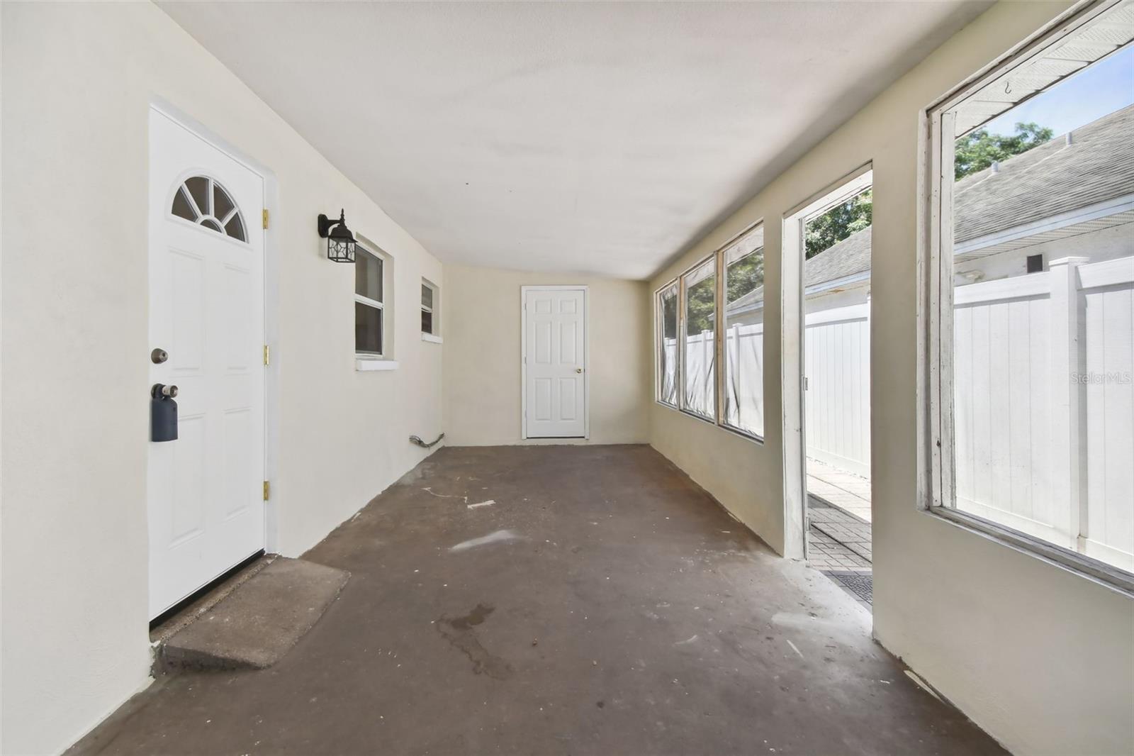 Large screen-enclosed side porch, leads to the interior of the home, the laundry/storage room and the backyard. Perfect for rainy day entertaining. Or enclose into a game/family room.