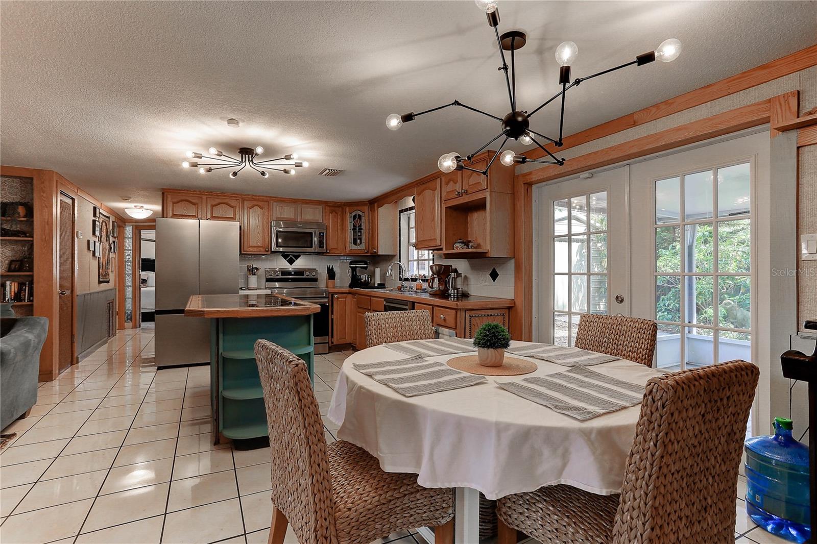Dinette and kitchen view.  French doors lead to screened porch with ceiling fan.
