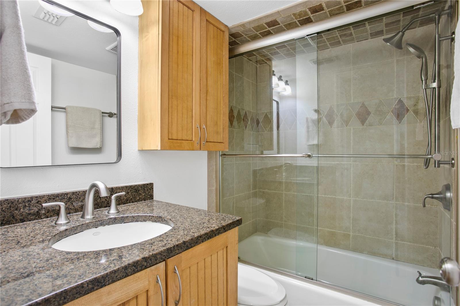 Guest Bathroom with tub/shower combination.  Note shower door is being removed.