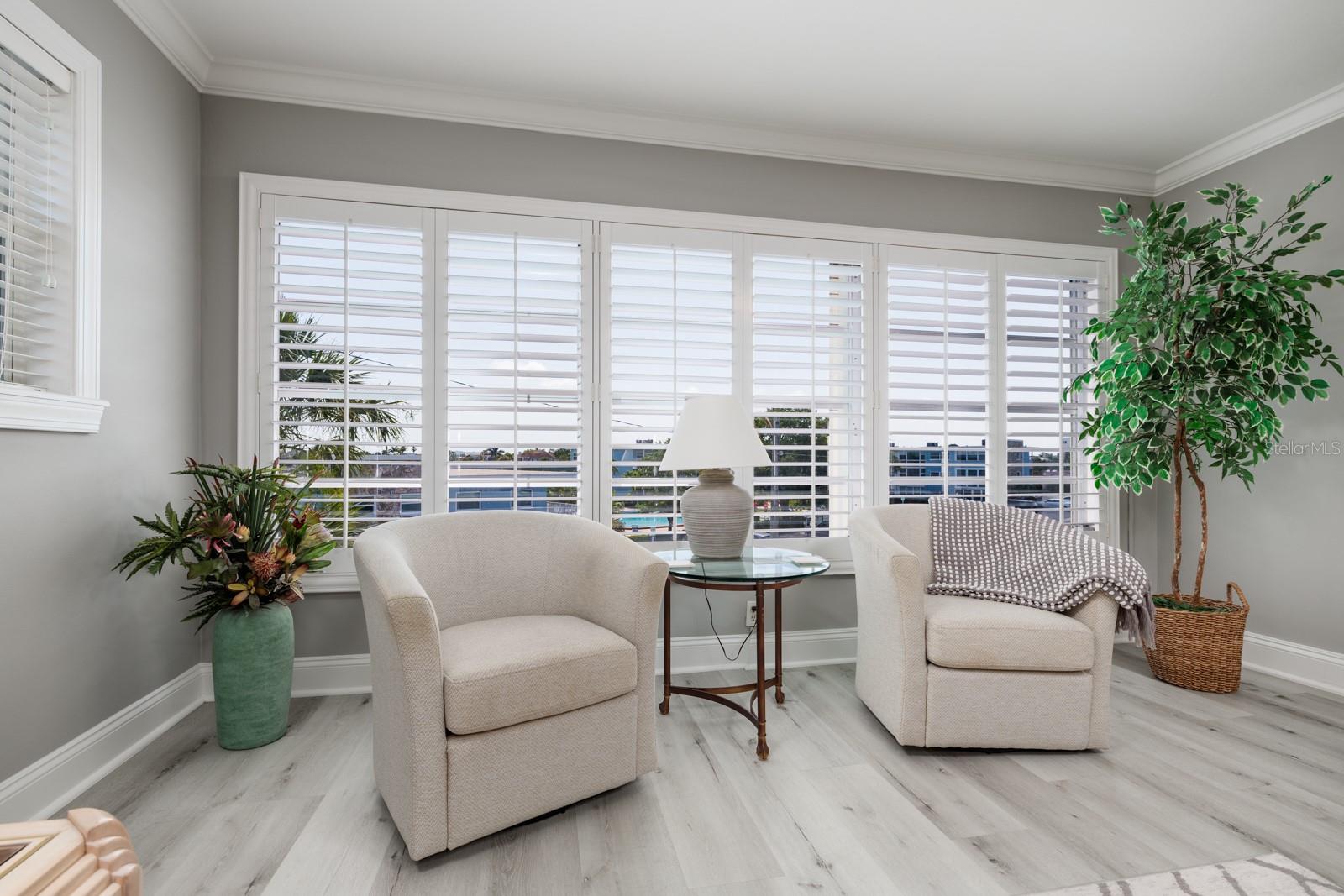 Large living room window w/pool & bay views. Plantation shutters. Window faces southeast.