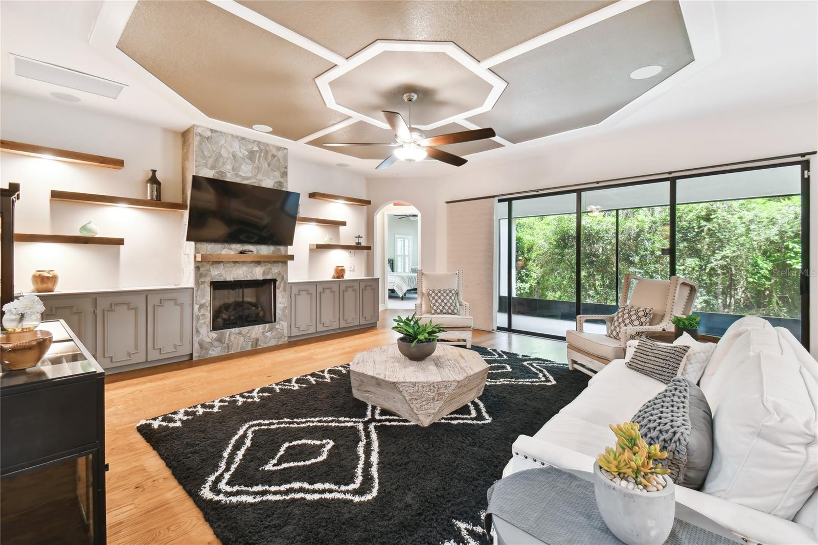 Gas fireplace with lighting shelving and built in cabinets.  Surround sound and elegant ceiling.