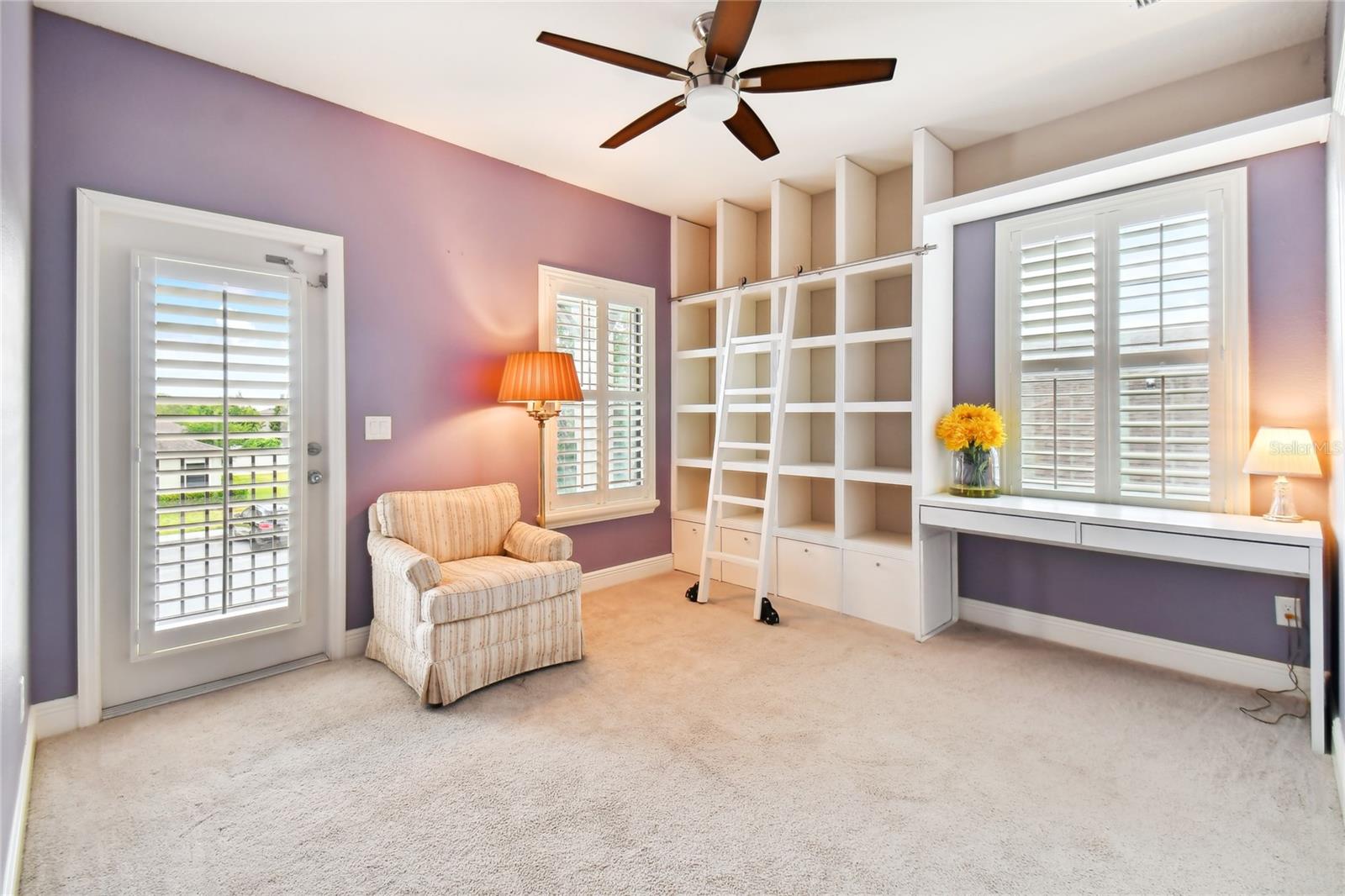 Bedroom 3 (2 on Floor Plan) with built-n bookcase and rolling ladder!  Door goes out to private balcony in front of the home.  Built-in desk!