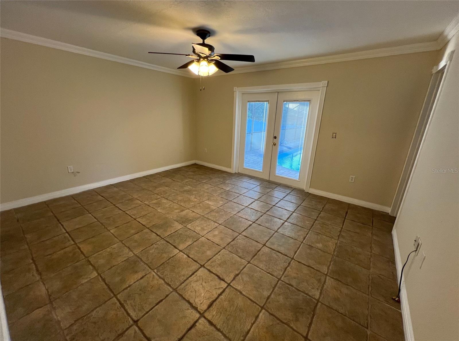 primary bedroom with French doors to pool