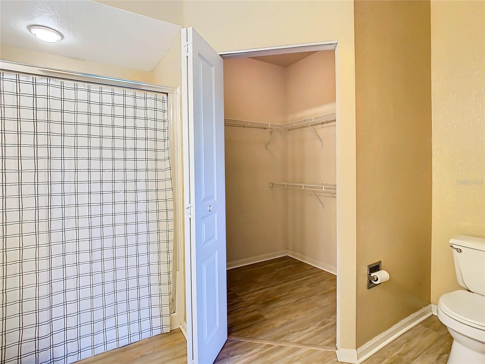 En-suite bath of primary bedroom with view of walk-in closet.