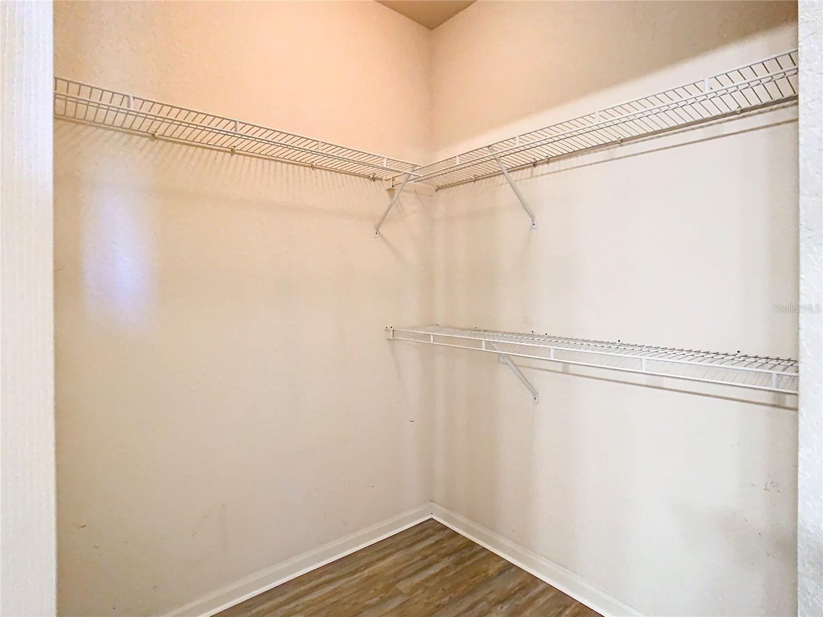 Walk-in closet inside of the en-suite bath of primary bedroom