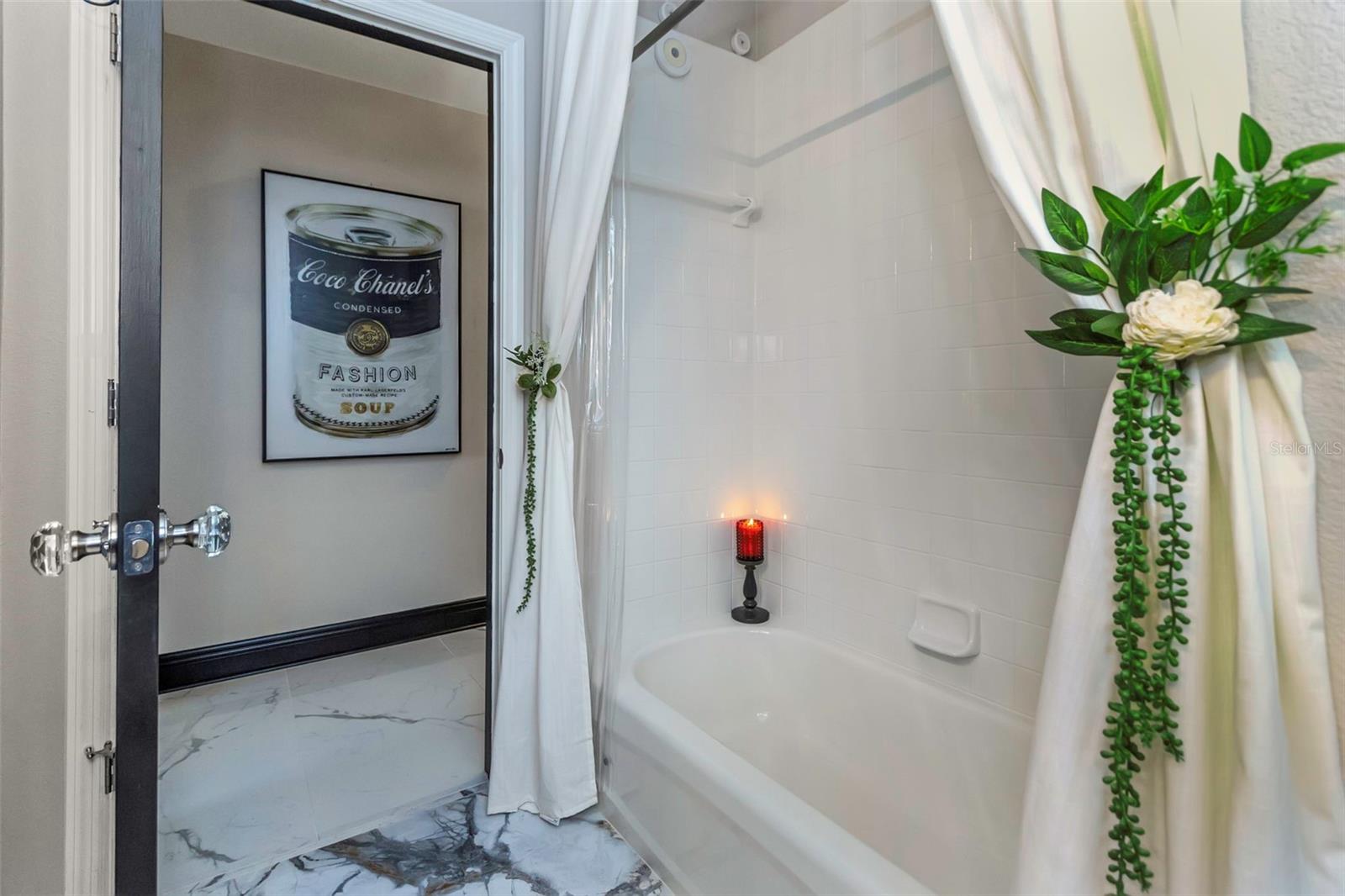 Hall bath with shower tub combination and polished porcelain tile