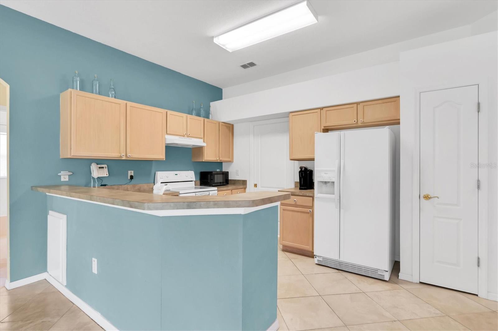 Kitchen with Plenty of Cabinet Space, Pantry, and Breakfast Bar