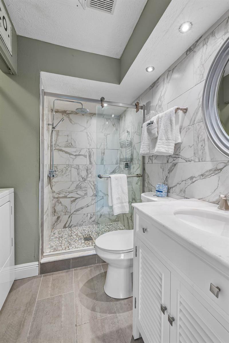 Guest bathroom with tiled shower and glass enclosure.