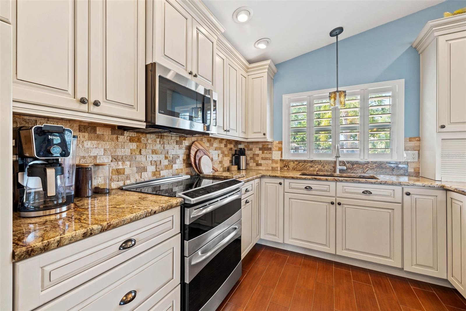 Custom KraftMaid cabinetry, stone backsplash, stainless appliances and with air fryer in the microwave