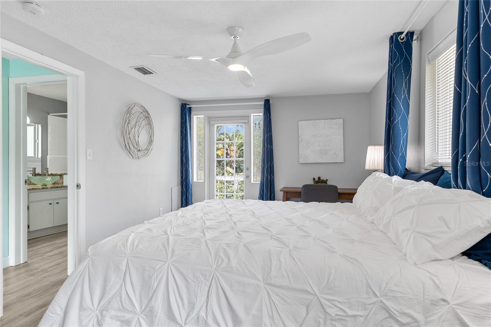 This view in the Primary Bedroom shows the Door that leads out to your very own deck overlooking the pool and back yard.