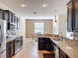 LARGE CHEF'S KITCHEN WITH GRANITE COUNTERTOPS AND 42" CABINETS, STAINLESS STEEL APPLIANCES AND SHARED SPACE WITH THE KITCHEN NOOK