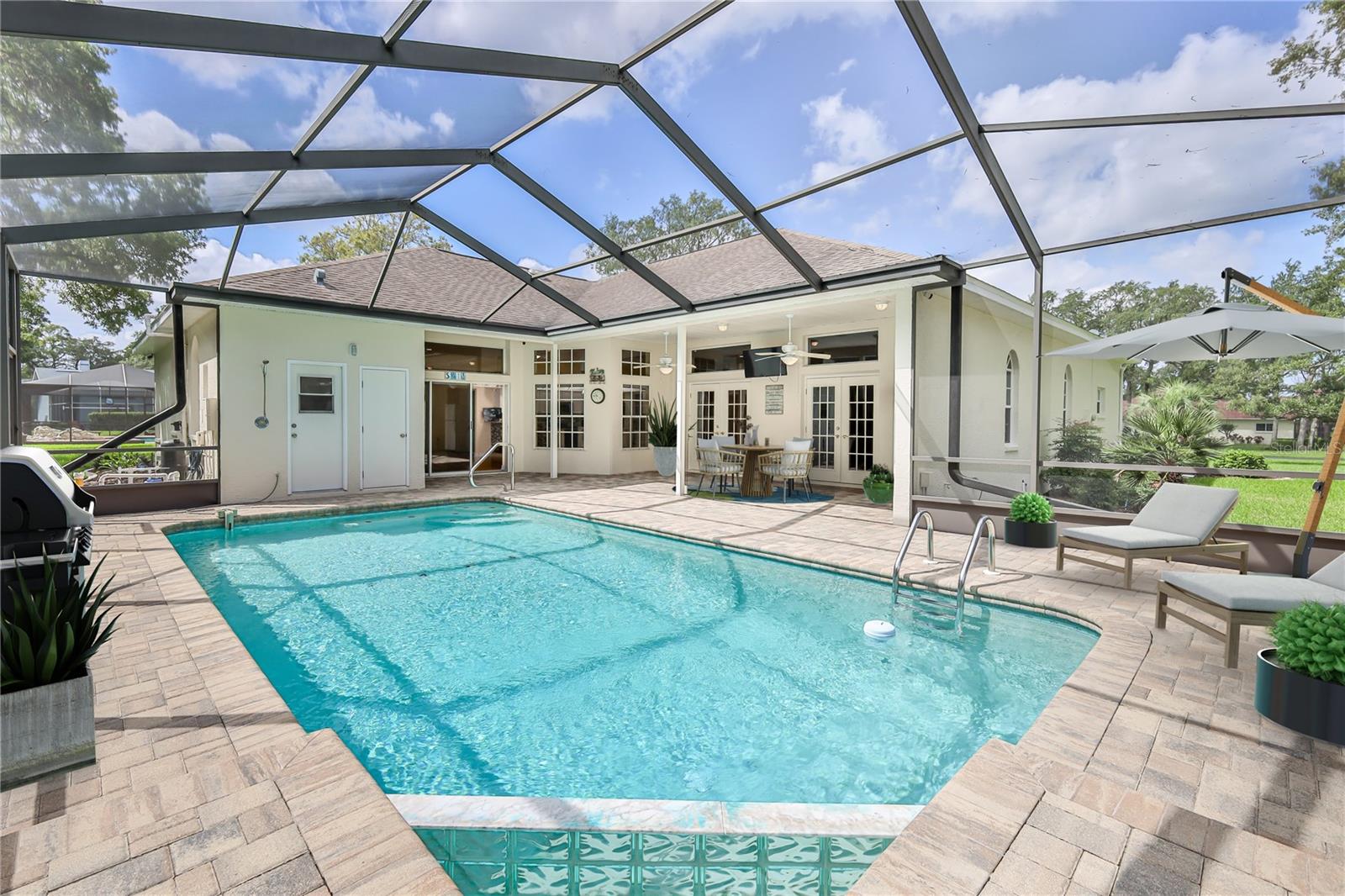 Solar Heated Pool with Waterfall Adorned by Pavers