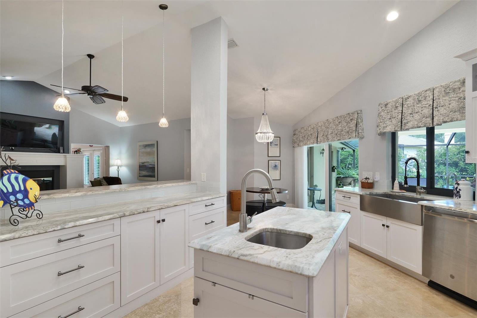 Island with bar sink, lots of counter space. Big stainless farm house sink, pull out drawers, custom cabinets, big window to look outside a sliding window to pass thing out to guest.