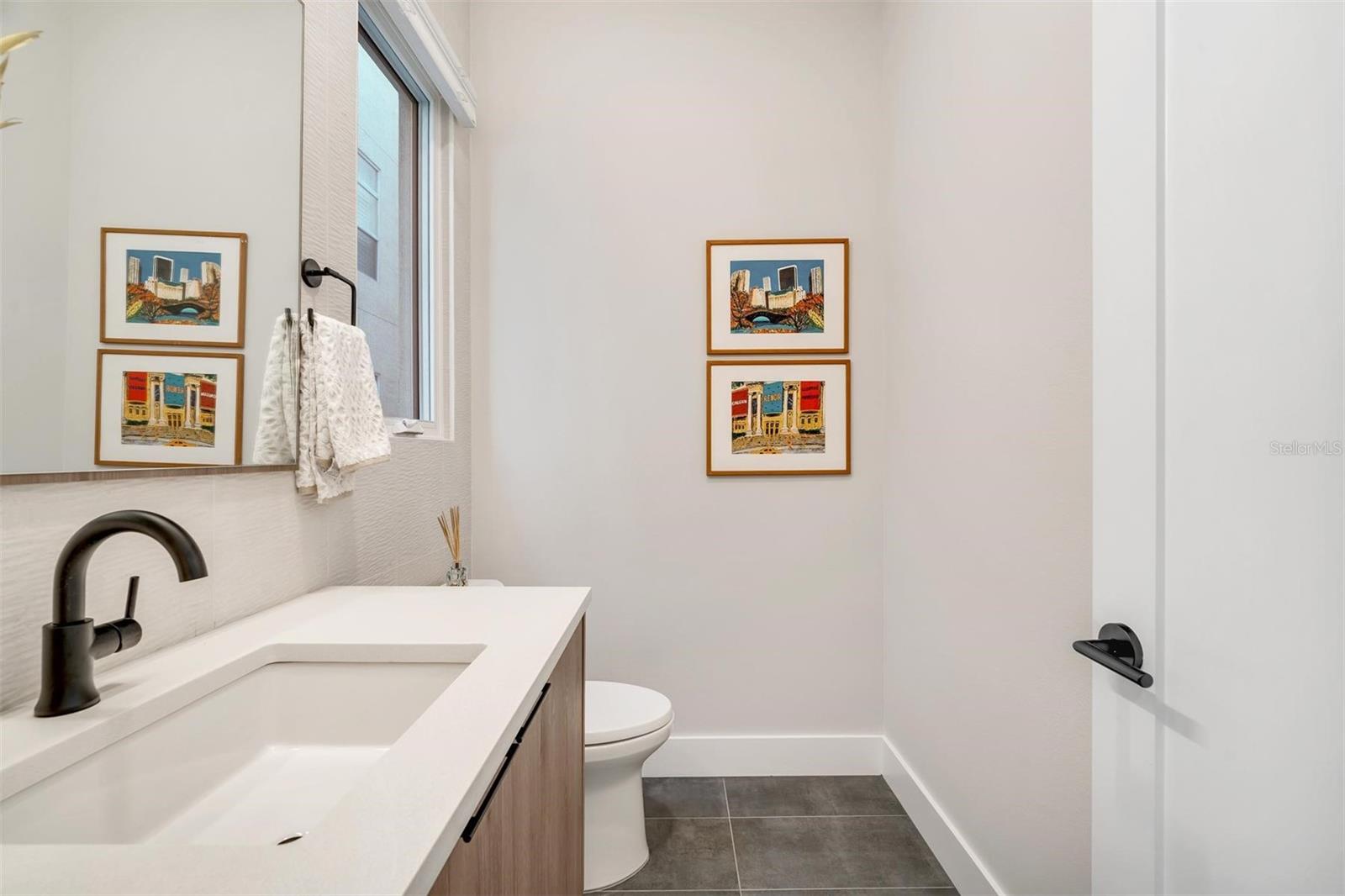 Second floor half bathroom featuring quartz countertops.