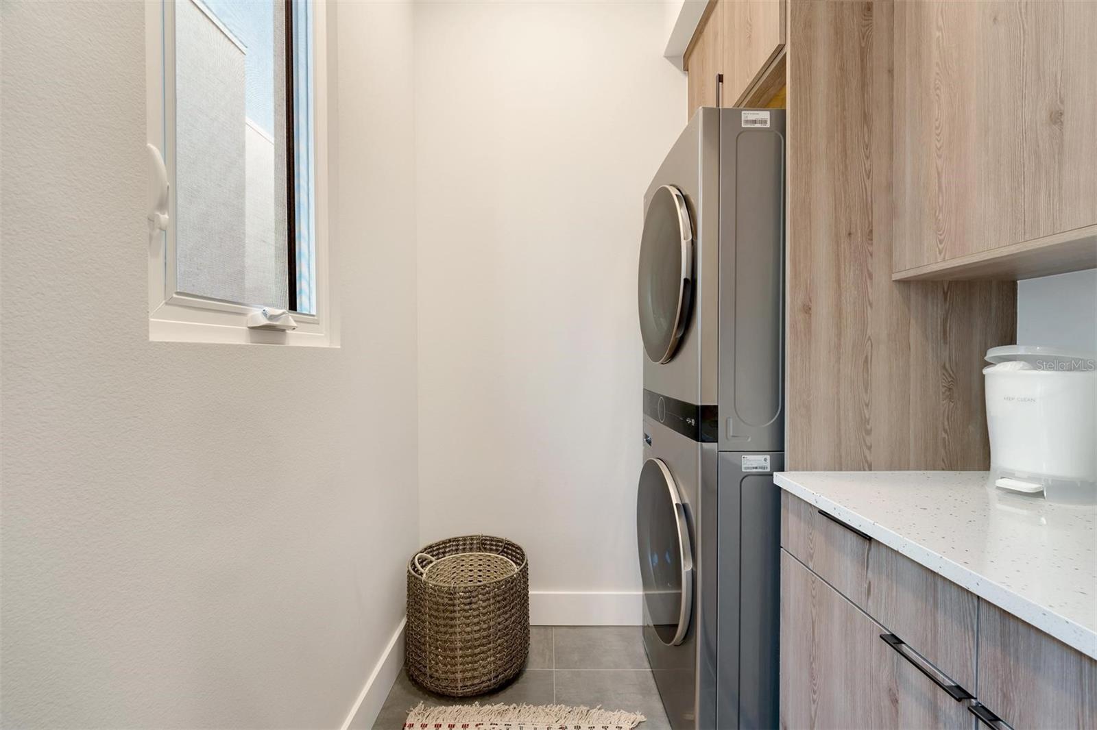 Upgraded laundry room feathering quartz countertops and shelving.