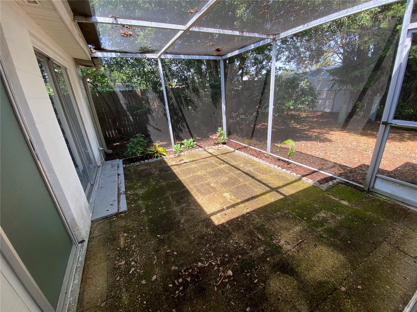 Screened patio area master bedroom and bathroom to left, photo taken from enclosed porch sliding glass door