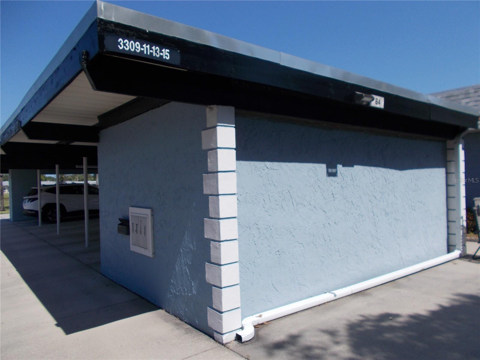 The mailbox is in front of the storage area.