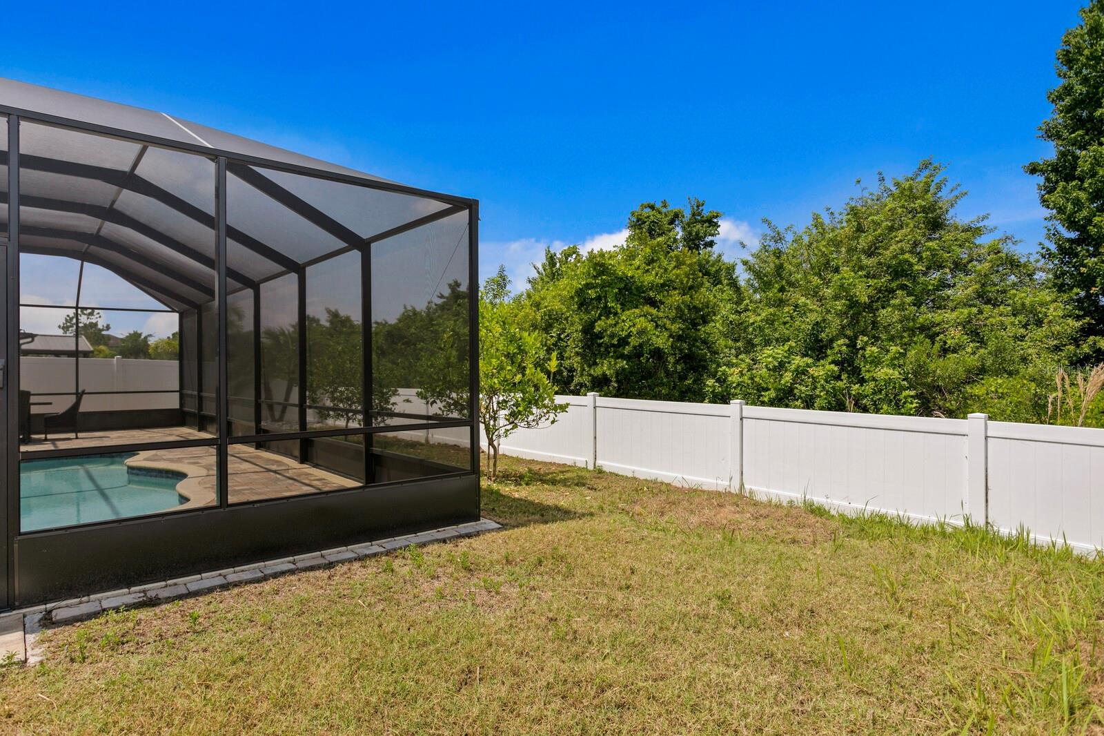 The white vinyl fence separates the backyard from the conservation area