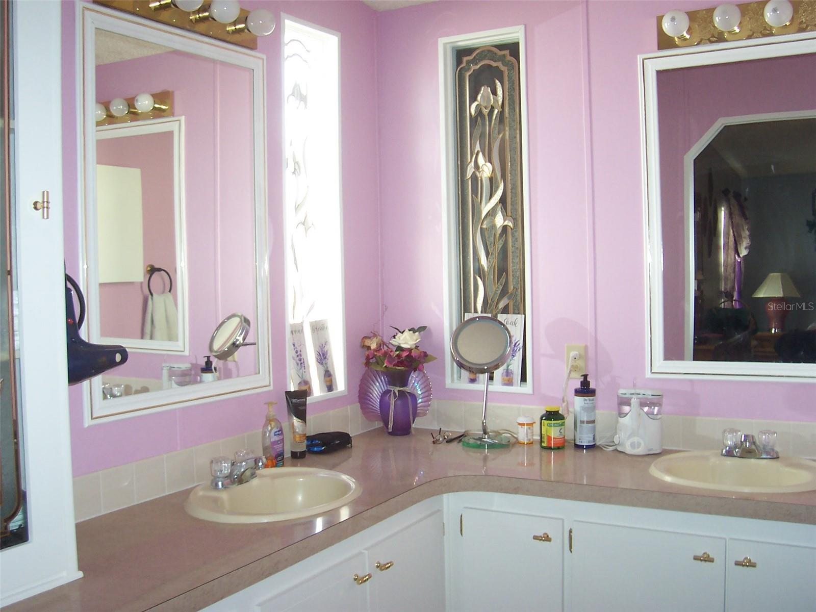 Primary Bathroom with double sinks and mirrors.  This bath features a walk in shower.