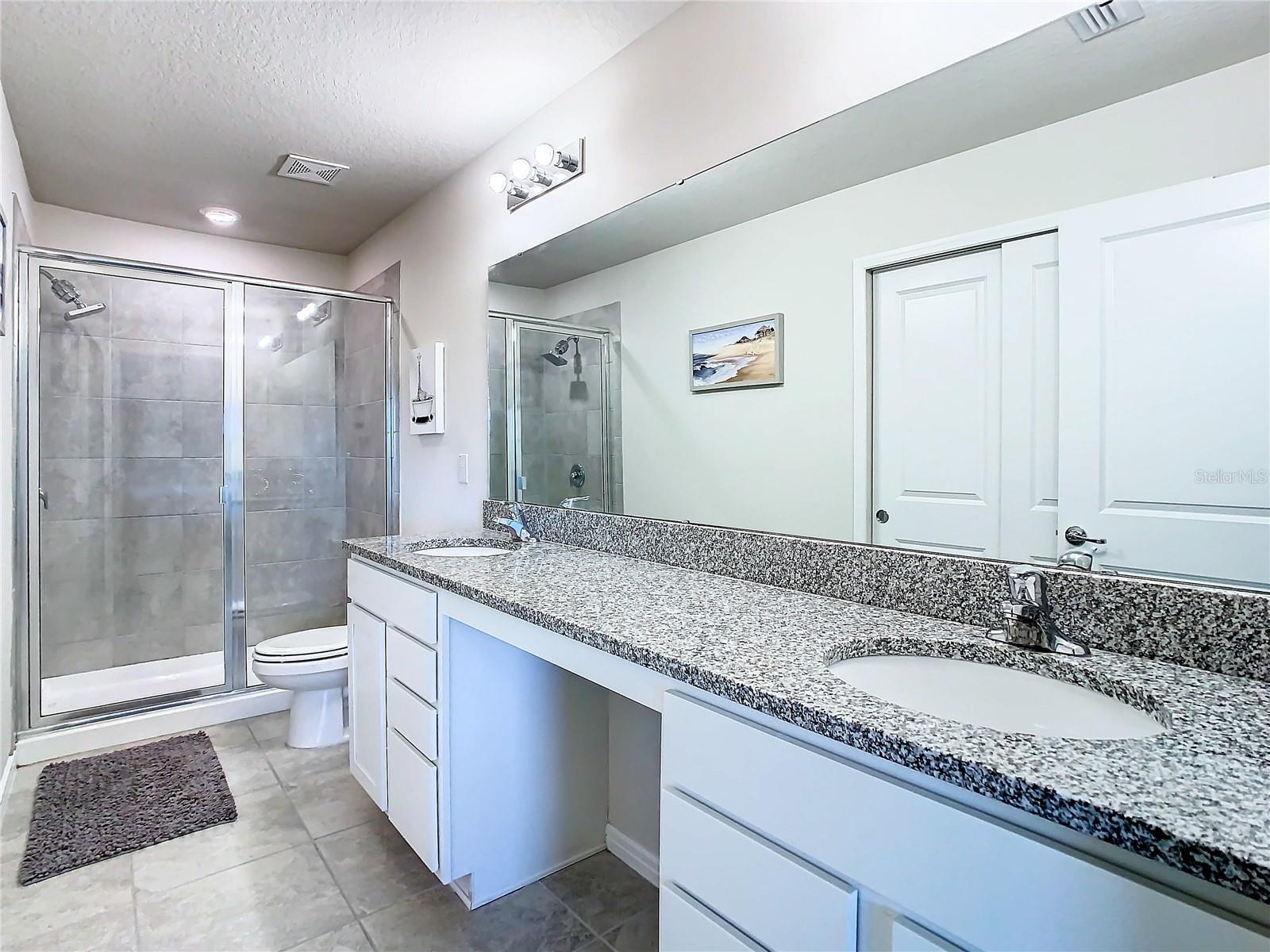 Primary bathroom with double sinks and granite counter top