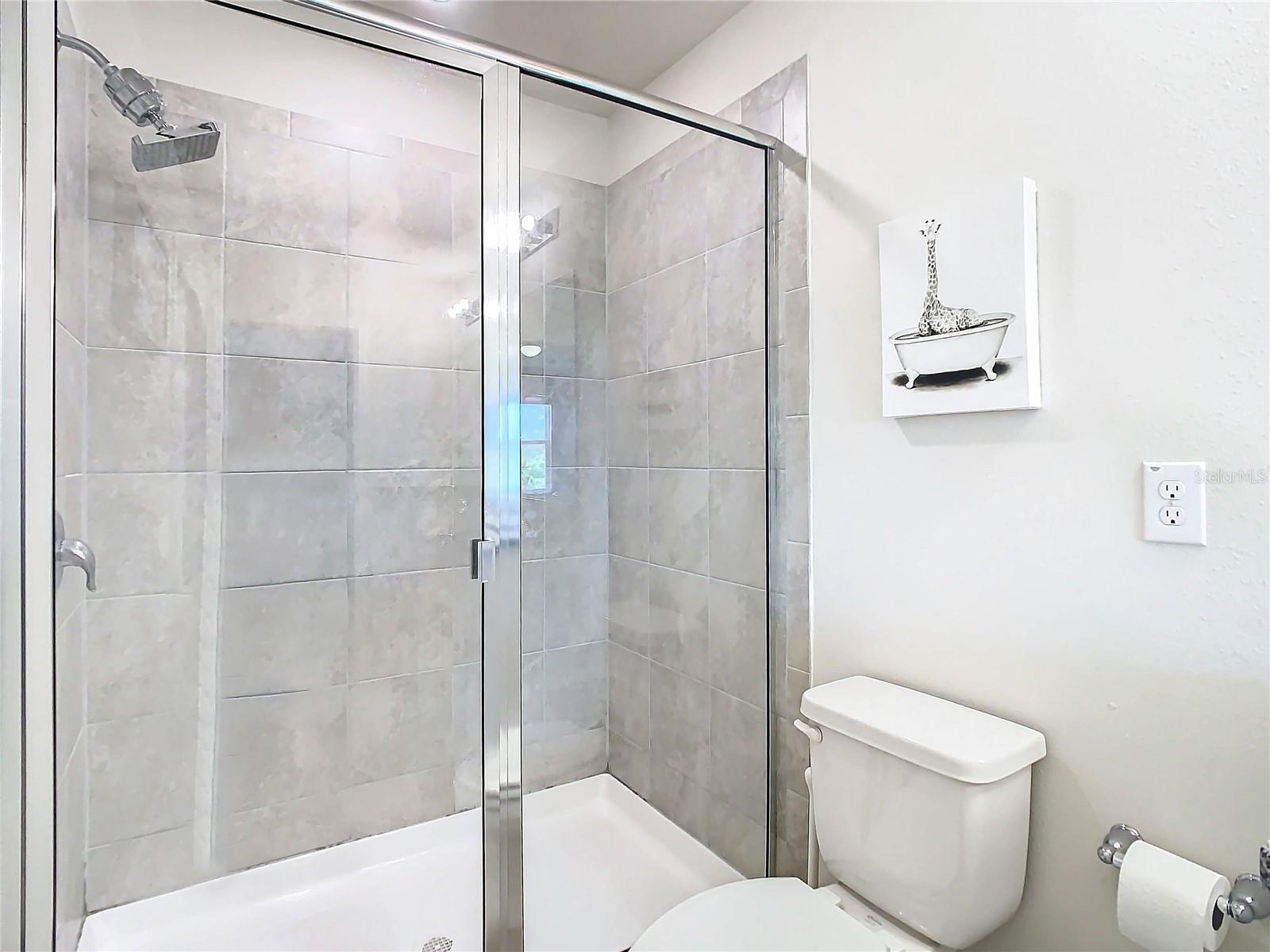 Primary bathroom with Upgraded tile and glass doors