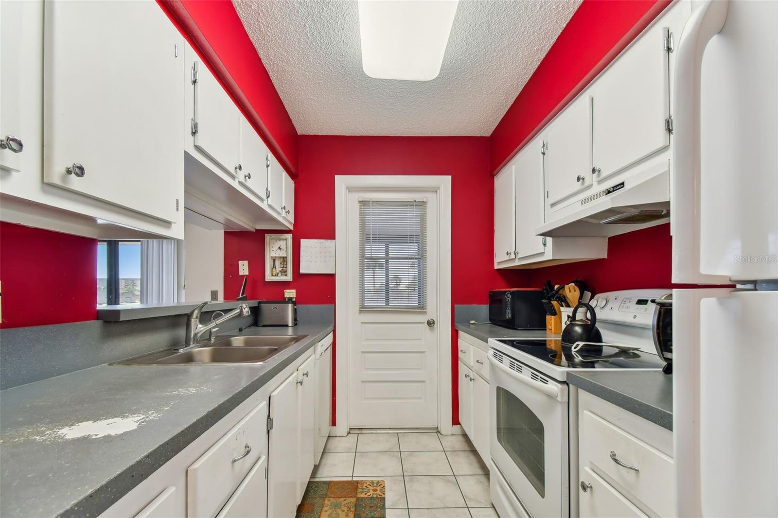 Kitchen with door to enclosed L shaped porch