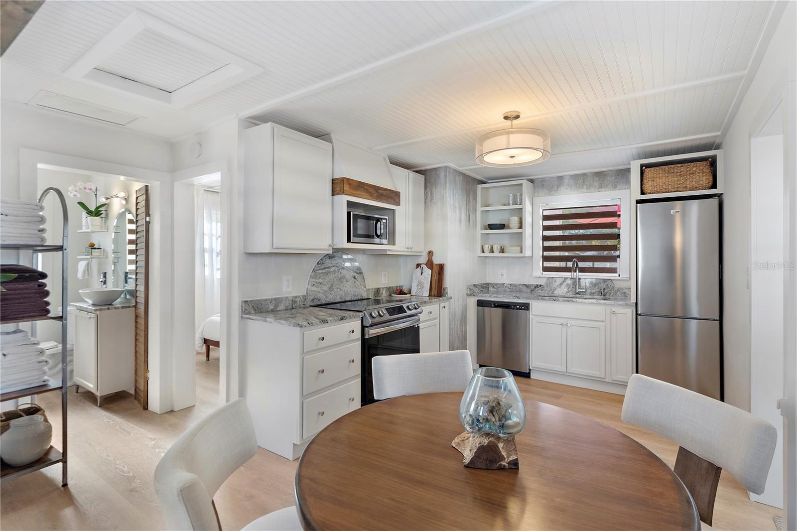 The kitchen features a full suite of BRAND NEW appliances, a stunning light fixture and granite counters with a smooth, polished finish exuding a timeless elegance and sophistication.