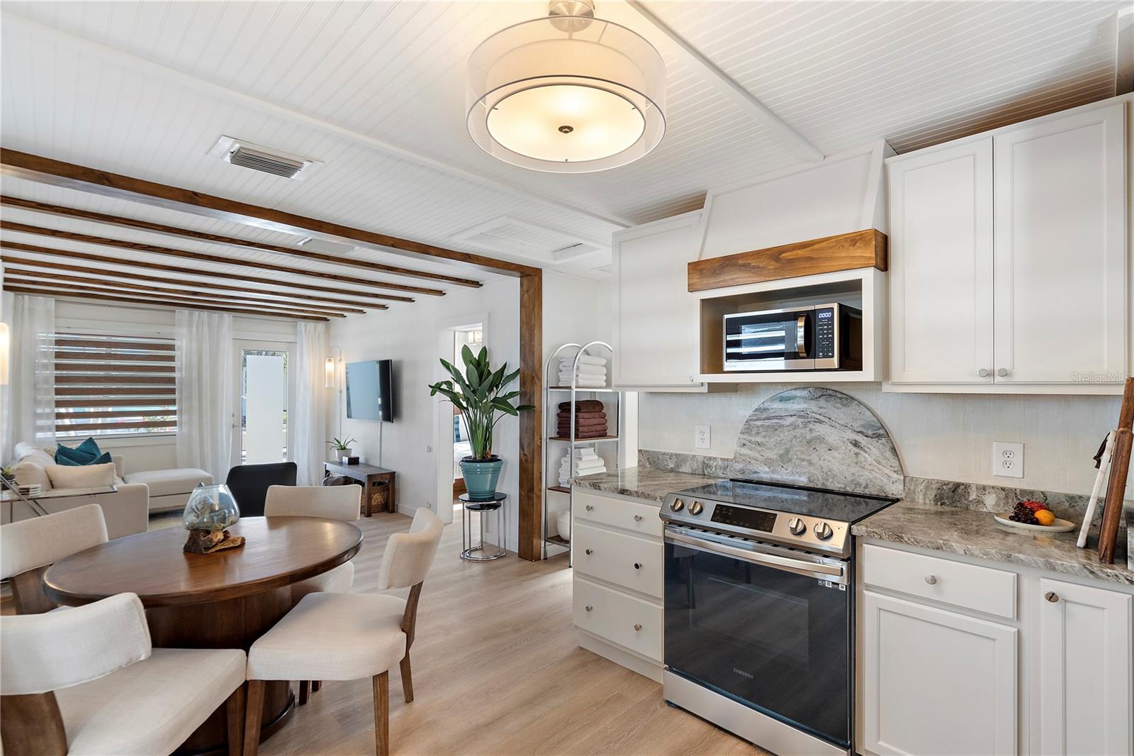The kitchen features a full suite of appliances, a stunning light fixture and granite counters with a smooth, polished finish exuding a timeless elegance and sophistication.