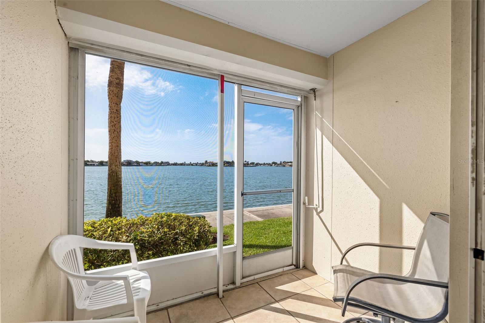 Gorgeous covered rear porch with hurricane shutter and water views