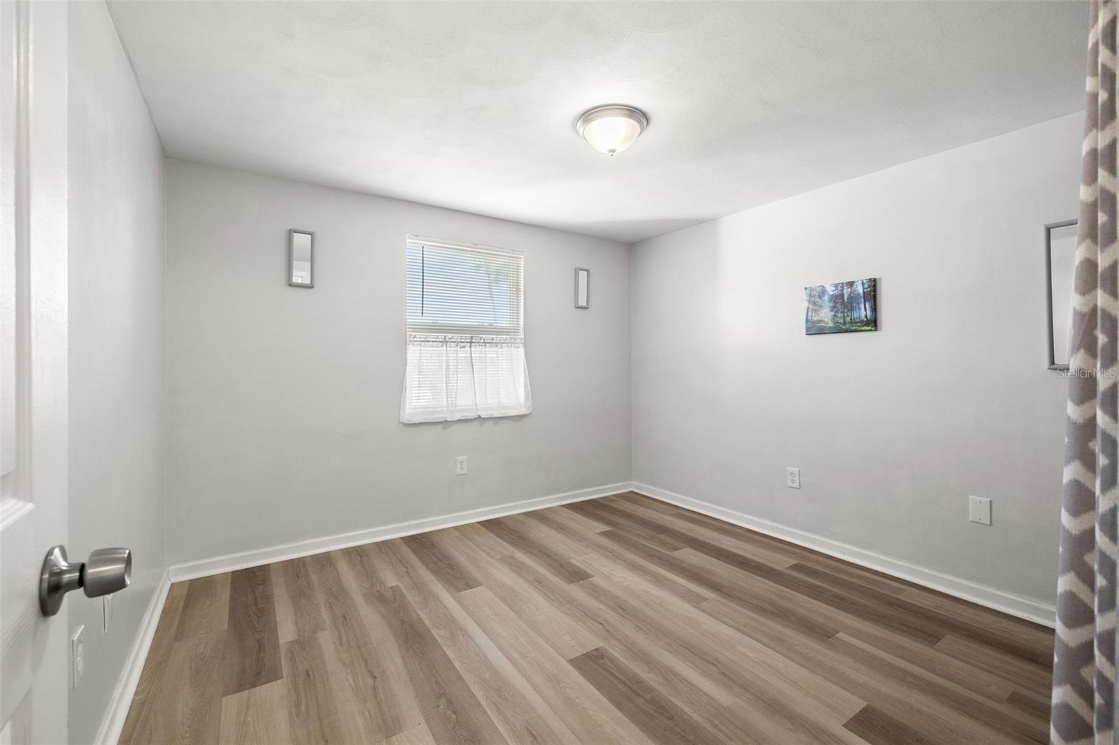 Front Bedroom features on-trend, neutral paint, luxury vinyl flooring and newer window.