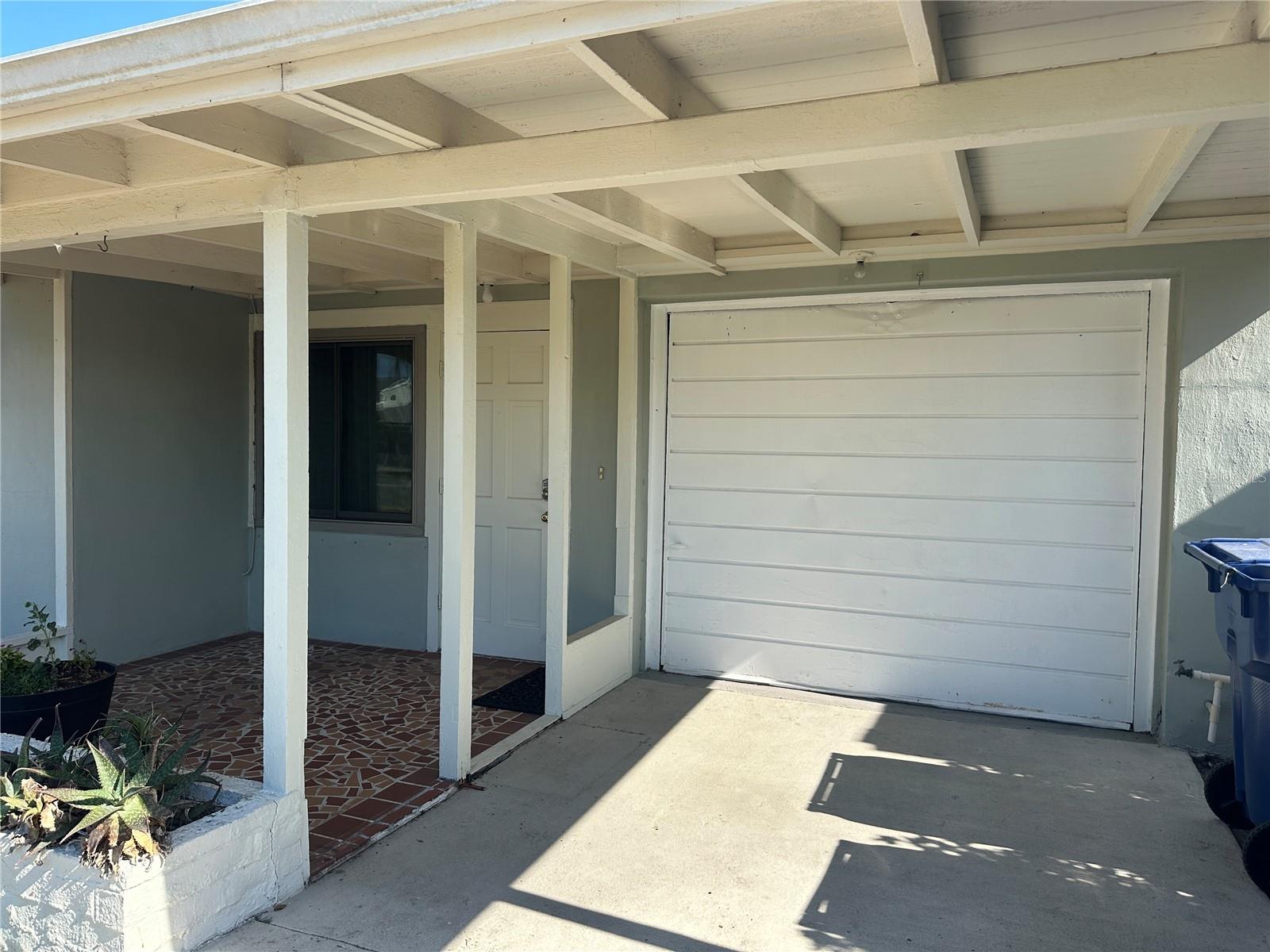 detail see how the roof of covered front patio extends to in front of garage