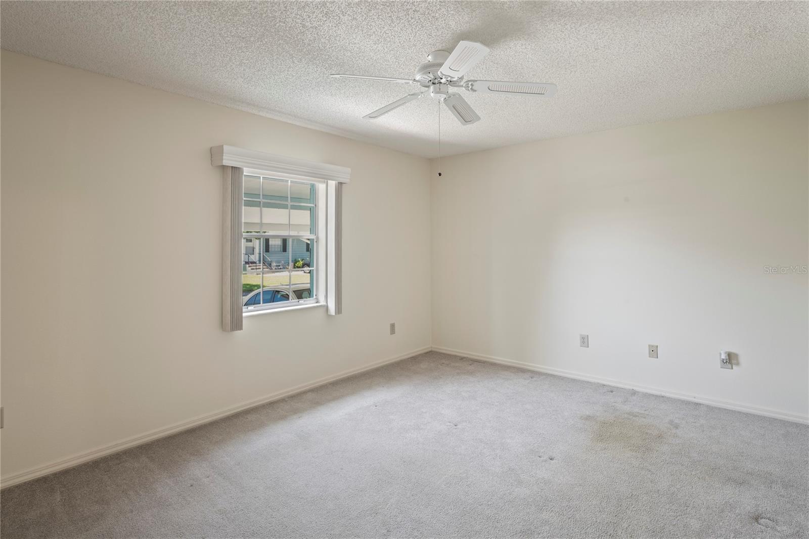 Primary bedroom has a ceiling fan, and a walk in closet