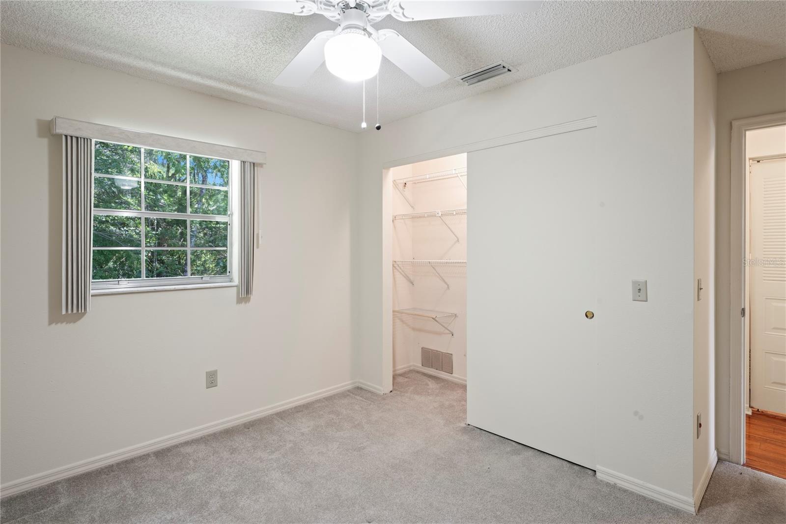 Guest bedroom showing the shelves in the closet and your view from the window