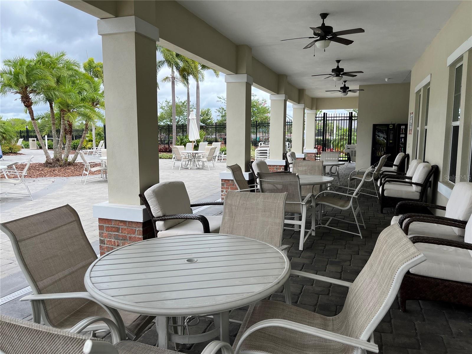 Covered patio next to pool and BBQ area, with restrooms and vending machines as well