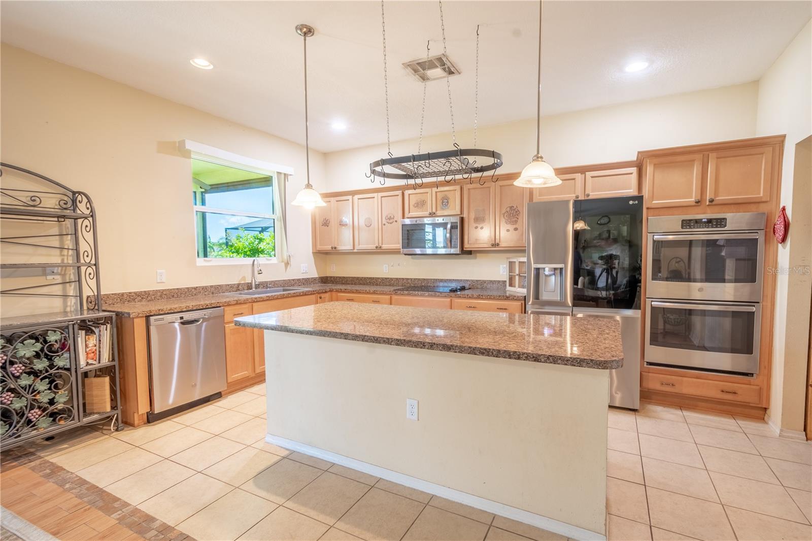 The kitchen features a large island and breakfast bar, with a granite countertop and additional storage.